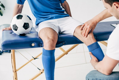 膝の施術を受けるサッカー少年